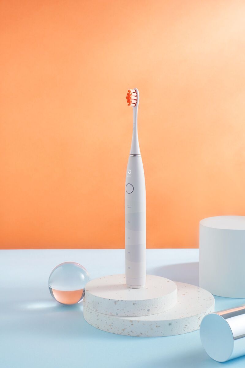 Cepillo dental sónico Oclean Flow sobre un soporte, en un bodegón de estudio